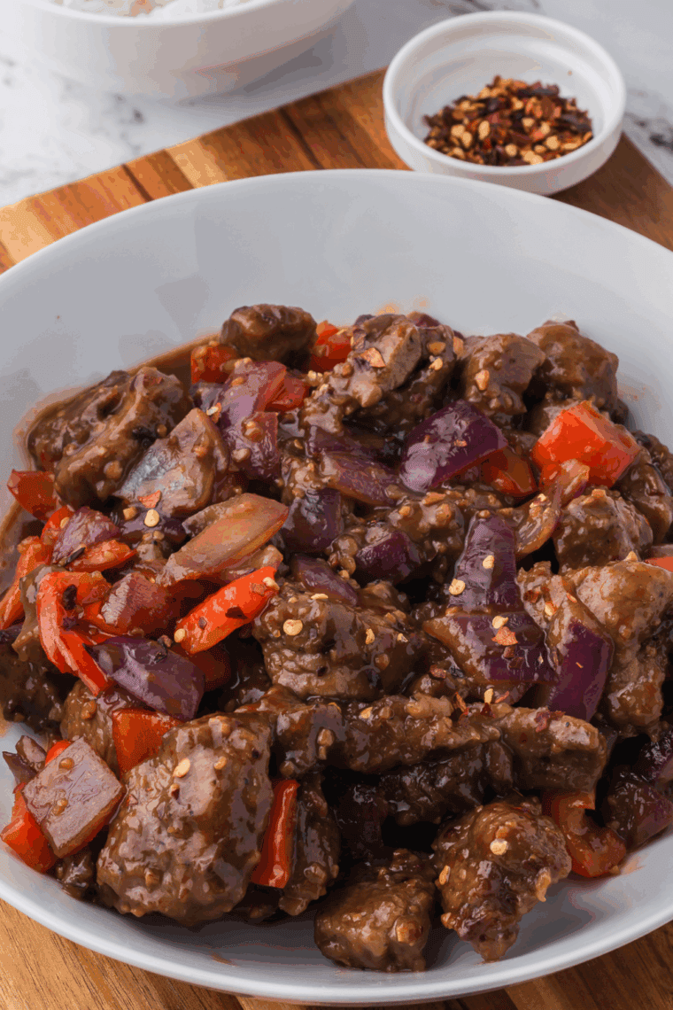 Crispy air fryer Beijing beef with bell peppers and onions in glossy sauce.