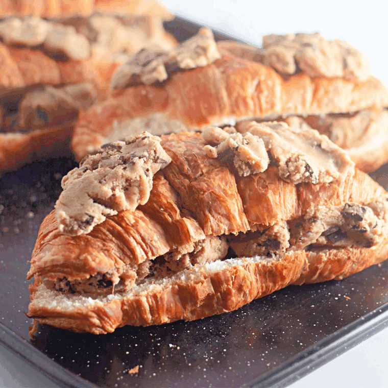 Stuffed croissant placed in air fryer basket, cooking until golden and gooey inside.
