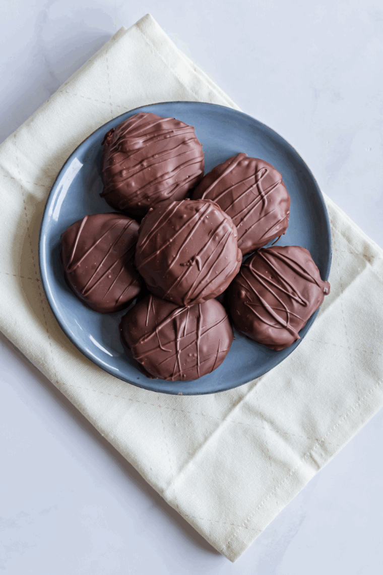 Homemade air fryer Tagalong cookies with a peanut butter layer and chocolate coating on a cooling rack.