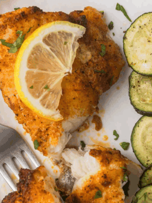 Crispy, golden-brown air fryer monkfish fillets served with lemon wedges and herbs.