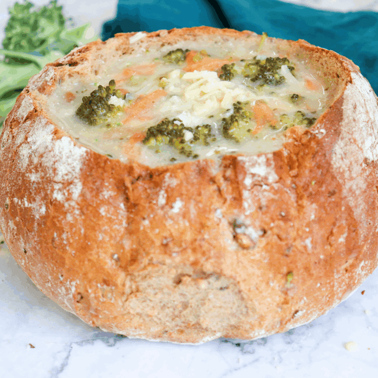 Bowl of creamy Applebee’s broccoli cheese soup topped with shredded cheddar

