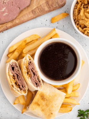 Homemade Arby’s Classic French Dip sandwich with melted cheese and au jus for dipping
