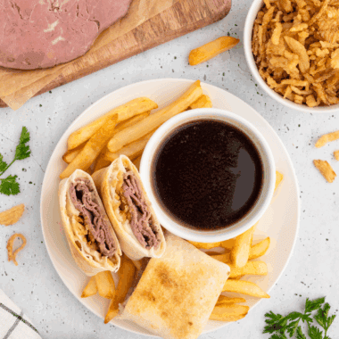 Homemade Arby’s Classic French Dip sandwich with melted cheese and au jus for dipping