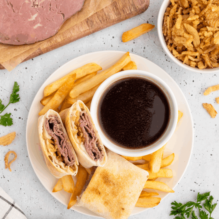 Homemade Arby’s Classic French Dip sandwich with melted cheese and au jus for dipping