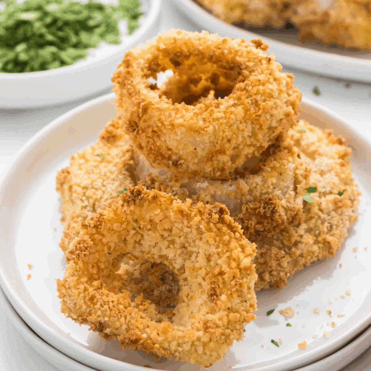 Homemade Arby’s steakhouse-style onion rings stacked on a plate, golden and crispy