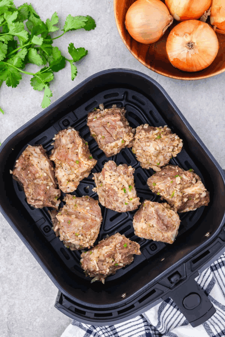 Place the carnitas meat in the air fryer basket in a single layer.