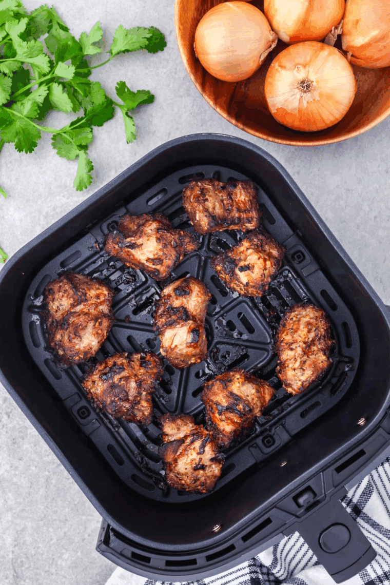 Cooked Carnitas in the air fryer basket.