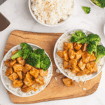 Grilled chipotle honey chicken sliced on a plate, served with lime and fresh cilantro.