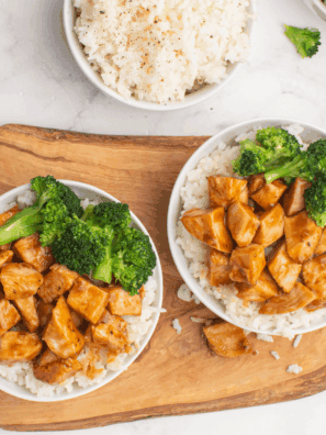 Grilled chipotle honey chicken sliced on a plate, served with lime and fresh cilantro.