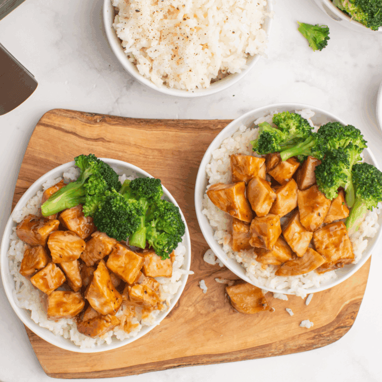 Grilled chipotle honey chicken sliced on a plate, served with lime and fresh cilantro.
