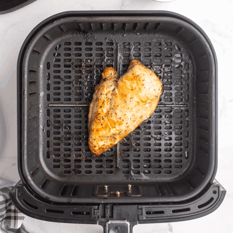 Cooking the chicken breast in the air fryer basket.