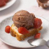 Chocolate Covered Strawberry Protein Ice Cream made in the Ninja Creami, served in a bowl with fresh strawberries and chocolate drizzle on top.