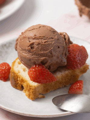 Chocolate Covered Strawberry Protein Ice Cream made in the Ninja Creami, served in a bowl with fresh strawberries and chocolate drizzle on top.