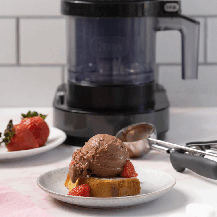 Creamy Chocolate Covered Strawberry Protein Ice Cream in a bowl, garnished with fresh strawberries and chocolate drizzle, made using the Ninja Creami.