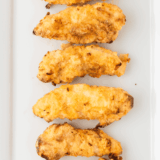 Golden fried Applebee’s copycat chicken tenders on a plate with dipping sauce.