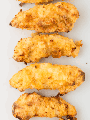 Golden fried Applebee’s copycat chicken tenders on a plate with dipping sauce.