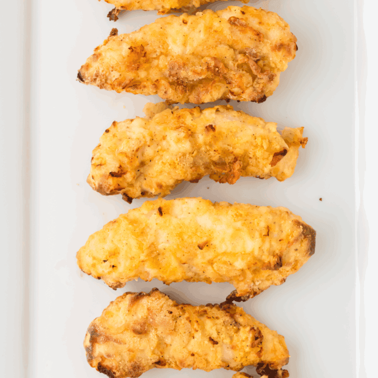 Golden fried Applebee’s copycat chicken tenders on a plate with dipping sauce.