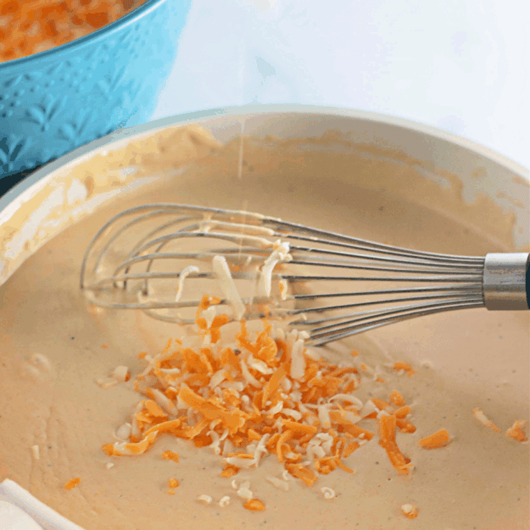 Stirring melted butter, milk, and cheese in a saucepan for creamy mac and cheese sauce.