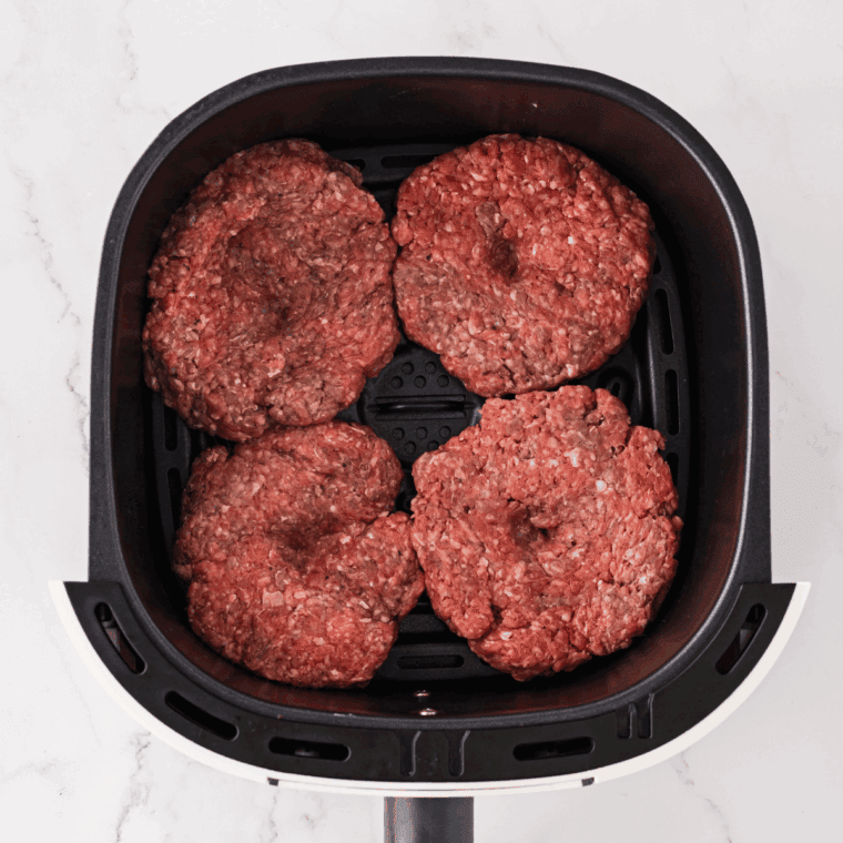 Place seasoned burgers in the air fryer basket.