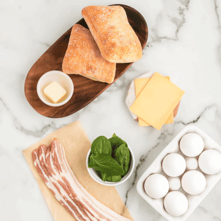 Ingredients needed for Copycat Starbucks Bacon Gouda Breakfast Sandwich on kitchen table.