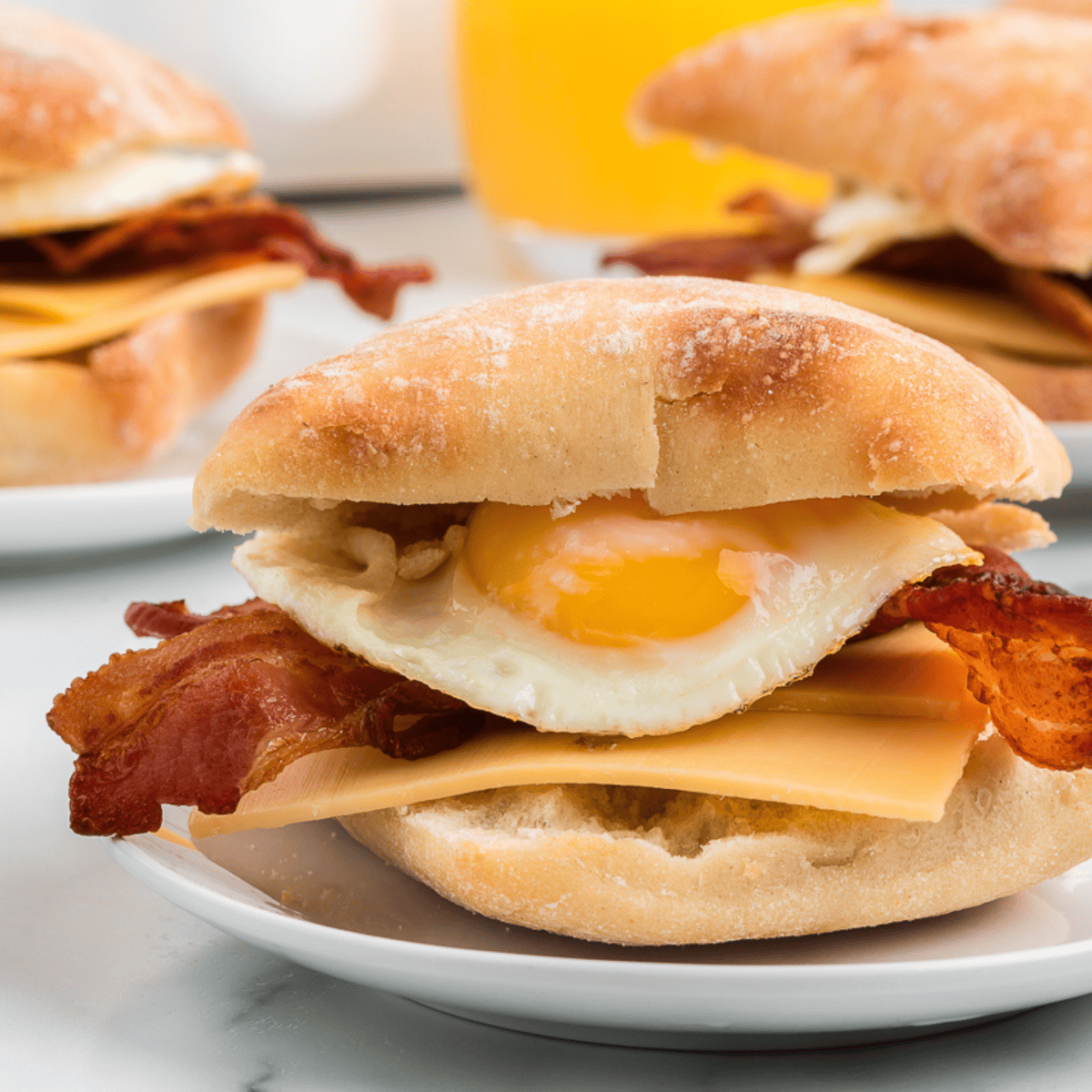 Homemade Starbucks-style bacon gouda breakfast sandwich on a toasted ciabatta bun with egg and melted cheese.
