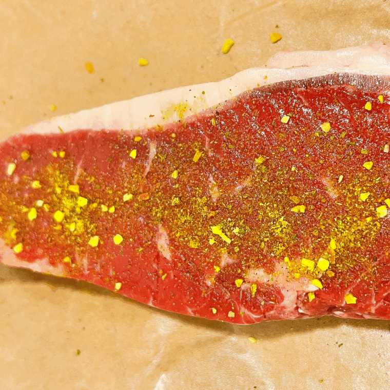 Patting steak dry and seasoning both sides with salt, pepper, steak seasoning, and garlic powder.