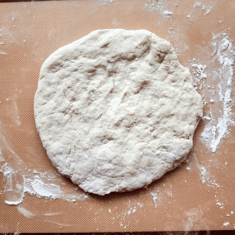 Dominos Pizza Dough Copycat Recipe being spread for a pizza.