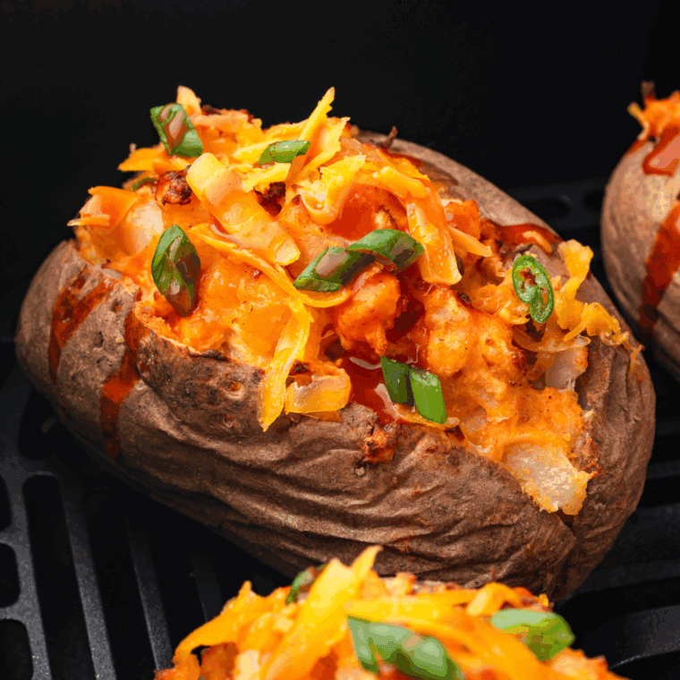 Baked potato stuffed with seasoned ground beef, melted cheese, and Mexican-inspired toppings.