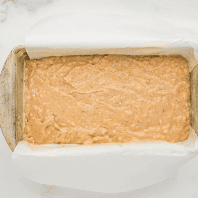 Banana bread batter poured into a loaf pan, ready to bake.