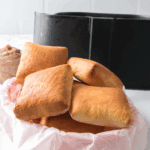 Freshly baked Golden Corral yeast rolls brushed with melted butter on a tray