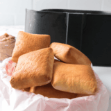 Freshly baked Golden Corral yeast rolls brushed with melted butter on a tray
