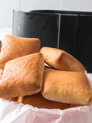 Freshly baked Golden Corral yeast rolls brushed with melted butter on a tray