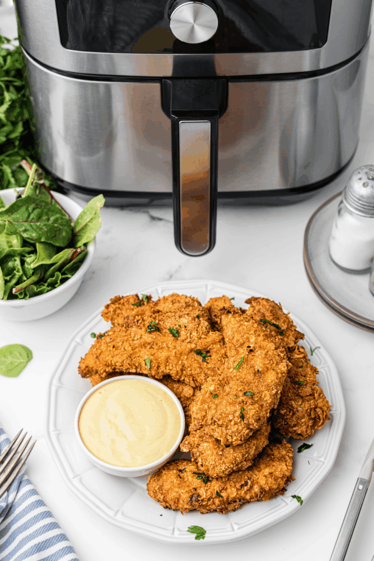 A bowl of hard honey mustard recipe next to the chicken tender.