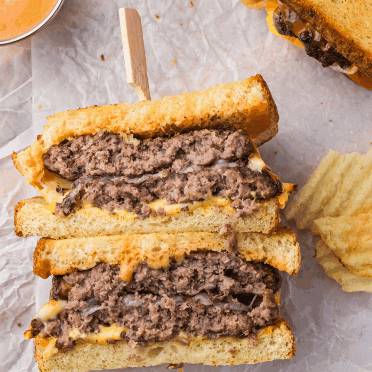 Hardee's Frisco Burger on kitchen table with chips and sauce on the side.