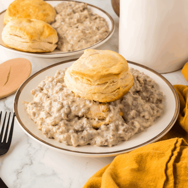 Plate of Hardee's Gravy Recipe with biscuits on top.
