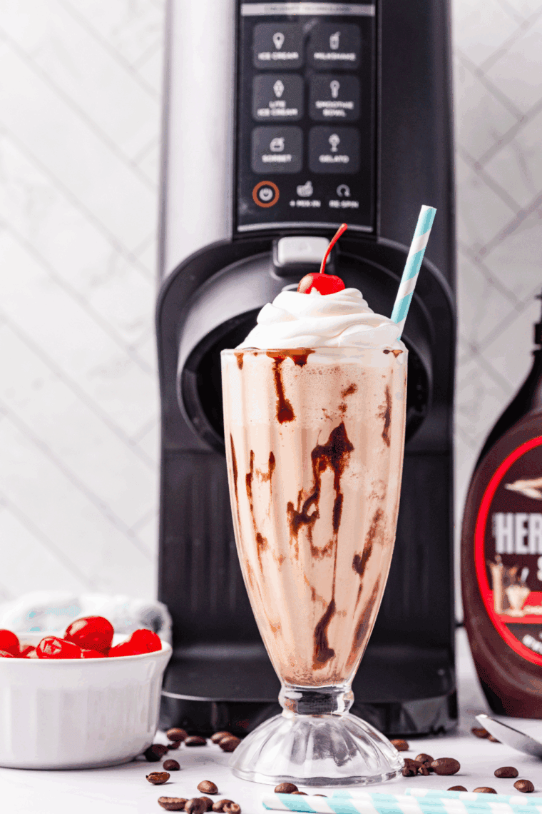 Glass of creamy Ninja Creami Jamocha Shake topped with whipped cream and chocolate drizzle