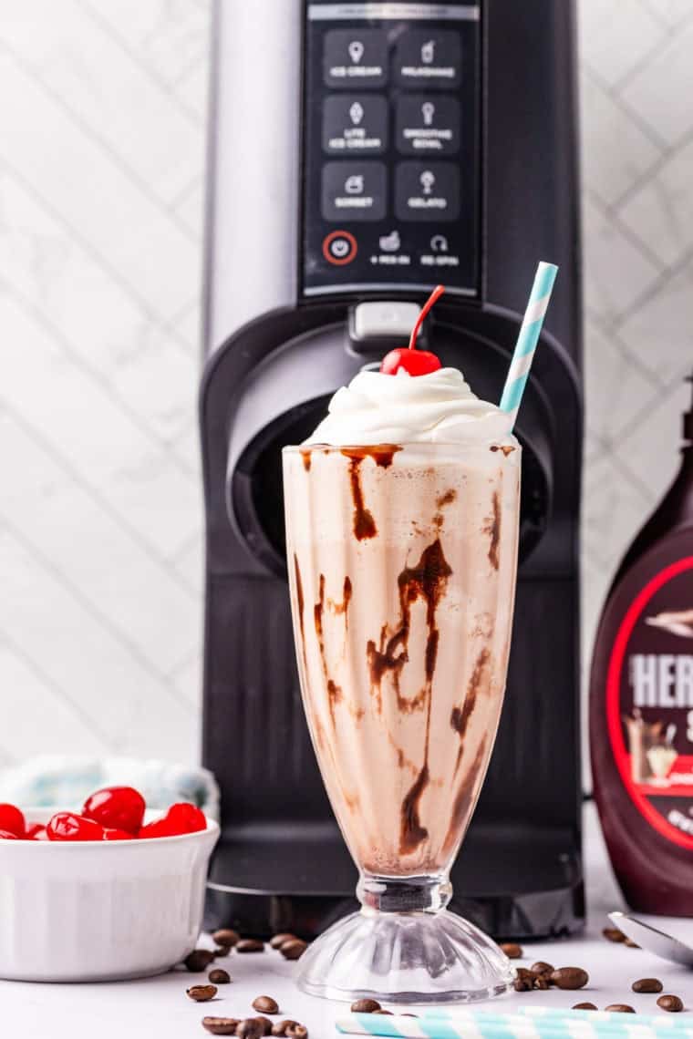 Glass of creamy Ninja Creami Jamocha Shake topped with whipped cream and chocolate drizzle