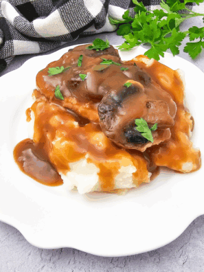 Bowl of homemade KFC copycat gravy served with mashed potatoes.