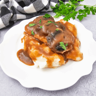 Bowl of homemade KFC copycat gravy served with mashed potatoes.