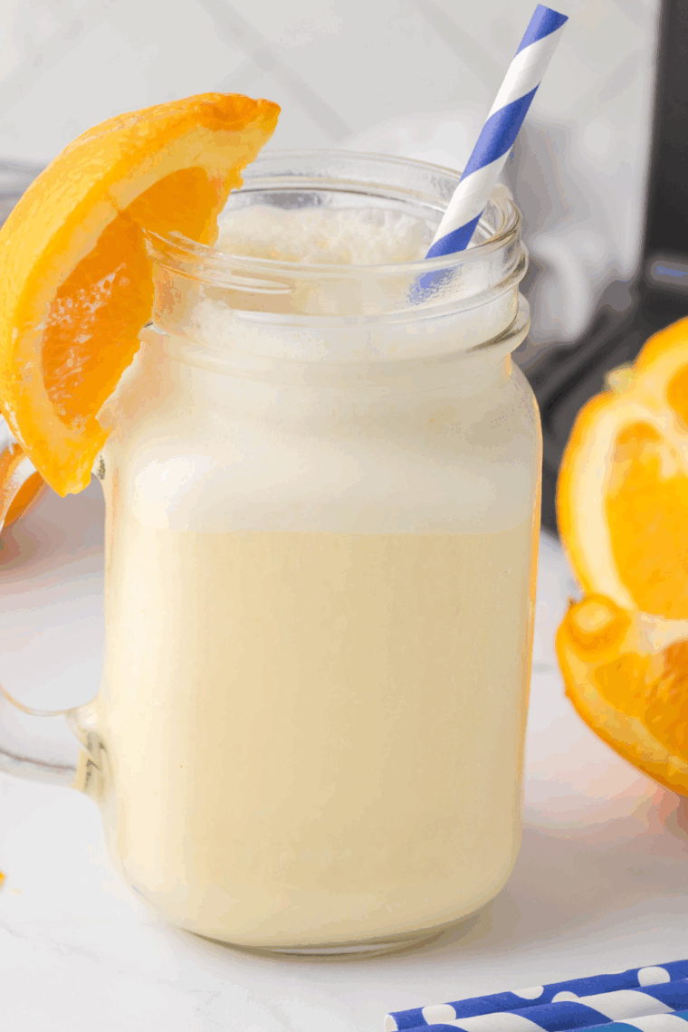 Homemade Ninja Creami Arby’s Orange Creamsicle Shake served in a tall glass with whipped cream on top.