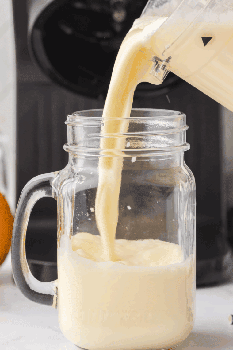 A glass of Ninja Creami Arby’s Orange Creamsicle Shake topped with whipped cream and orange slices.