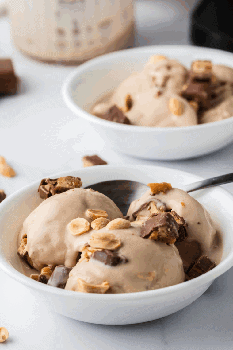 Ninja Creami Snickers Blizzard Copycat topped with chopped Snickers bars in a bowl.