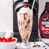 Glass of homemade Ninja Creami Jamocha Shake topped with whipped cream and chocolate drizzle