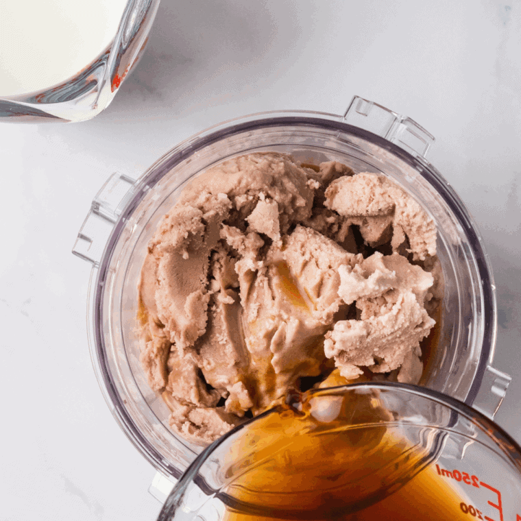 Ingredients including chocolate ice cream, milk, coffee, and chocolate syrup added to a blender.