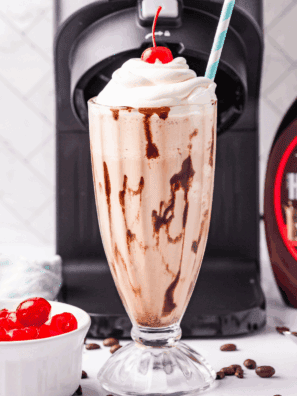 Glass of homemade Ninja Creami Jamocha Shake topped with whipped cream and chocolate drizzle