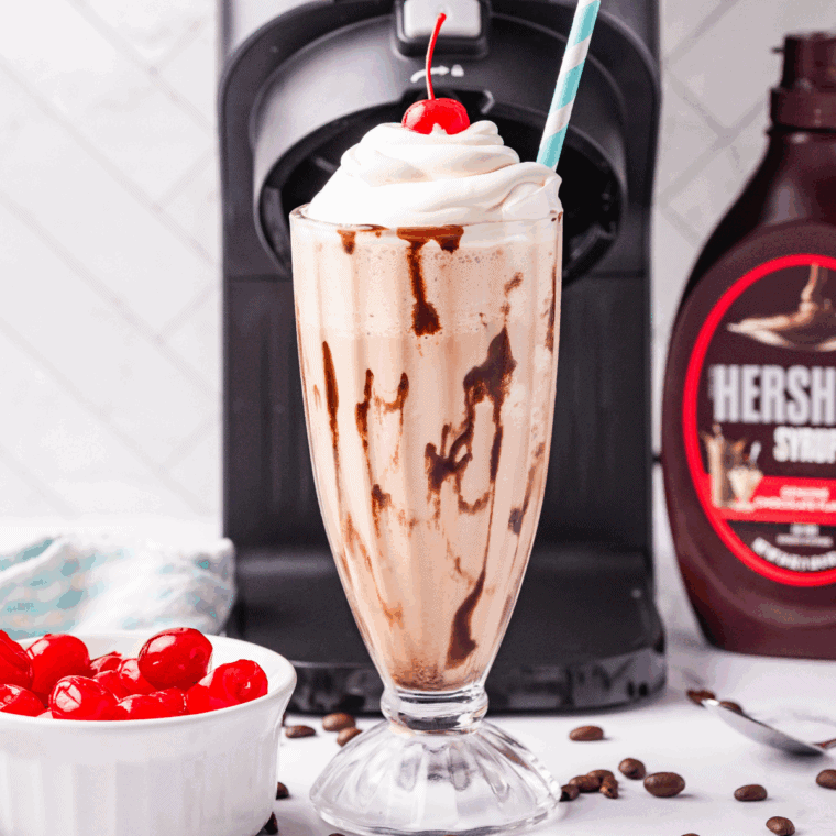 Glass of homemade Ninja Creami Jamocha Shake topped with whipped cream and chocolate drizzle