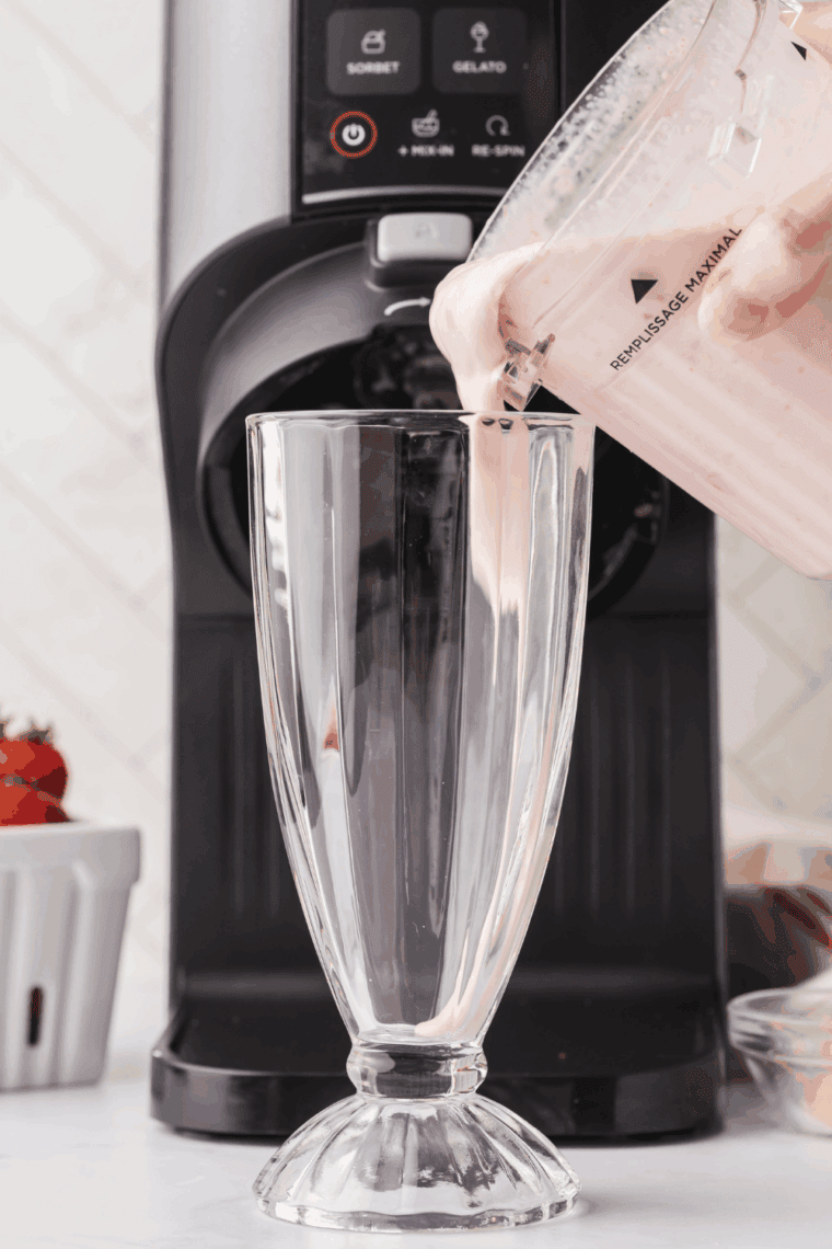 Pouring Ninja Creami McDonald's Strawberry Milkshake into a glass.