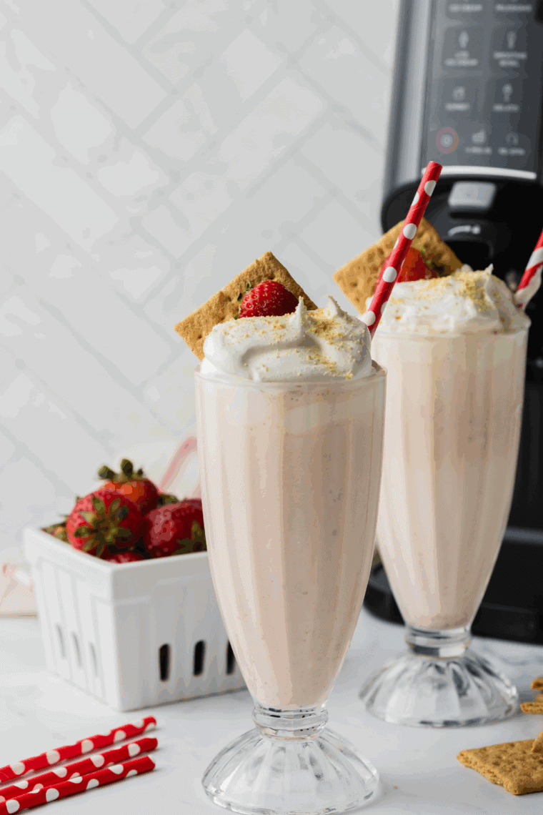 Ninja Creami McDonald's Strawberry Milkshake in a glass with fresh strawberries on the side.
