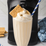 Ninja Creami vanilla milkshake in glass topped with whipped cream and cherry, McDonald’s copycat style.