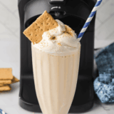 Ninja Creami vanilla milkshake in glass topped with whipped cream and cherry, McDonald’s copycat style.